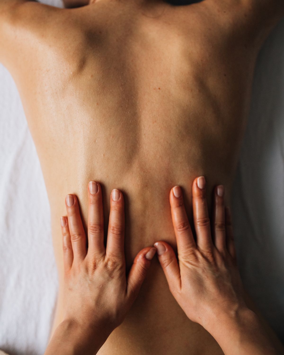 Close-up of a therapist's hands working on a client's back
